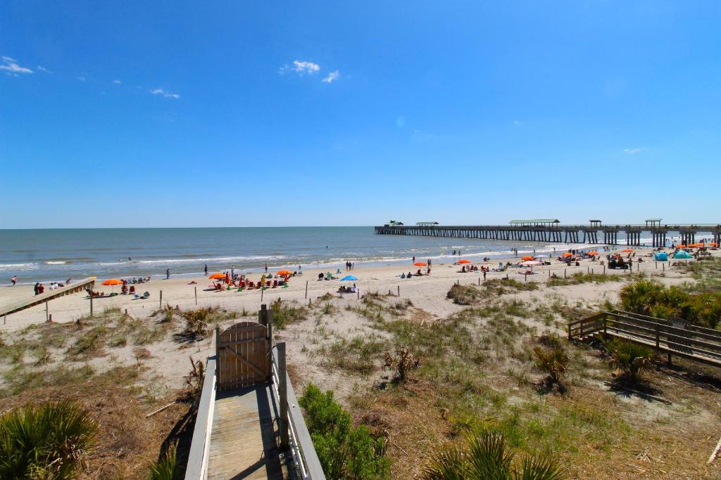 a view of a beach with people and a pier at Beautiful Sunrise in Folly Beach