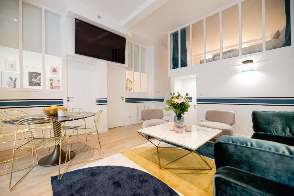 un salon avec un canapé et une table dans l'établissement CIA - Vosges Gem, à Paris