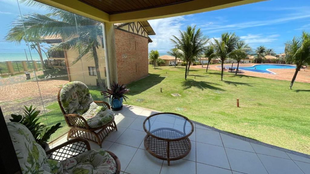 a porch with chairs and a view of a pool at Apartamento Encantador Térreo Piscina B04 in Rio do Fogo