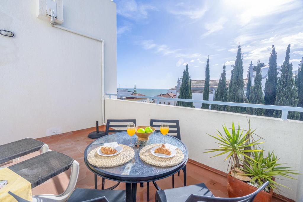 a table with two plates of food on a balcony at Bay View by OCvillas in Albufeira