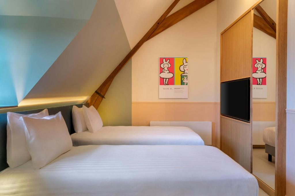Postel nebo postele na pokoji v ubytování The Rebyl, Nijmegen, a Tribute Portfolio Hotel