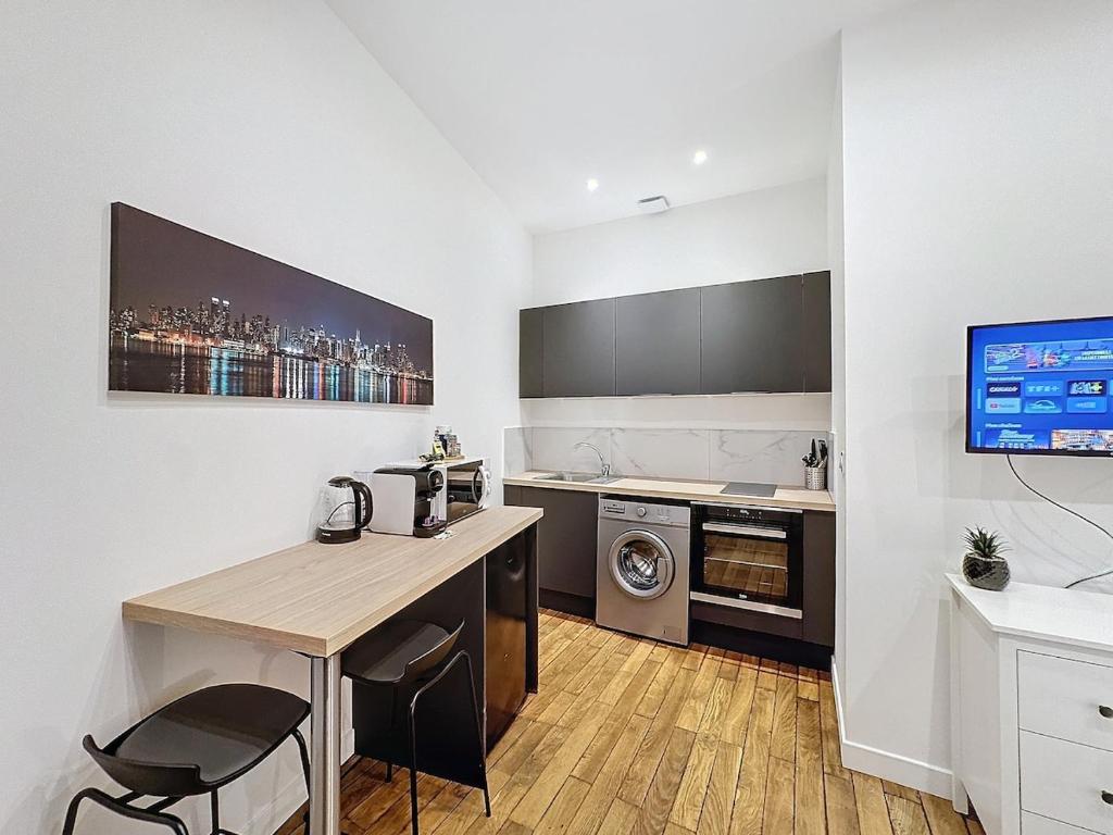 een keuken met een tafel en een aanrechtblad bij My Home Saint Jérôme 1 in Lyon