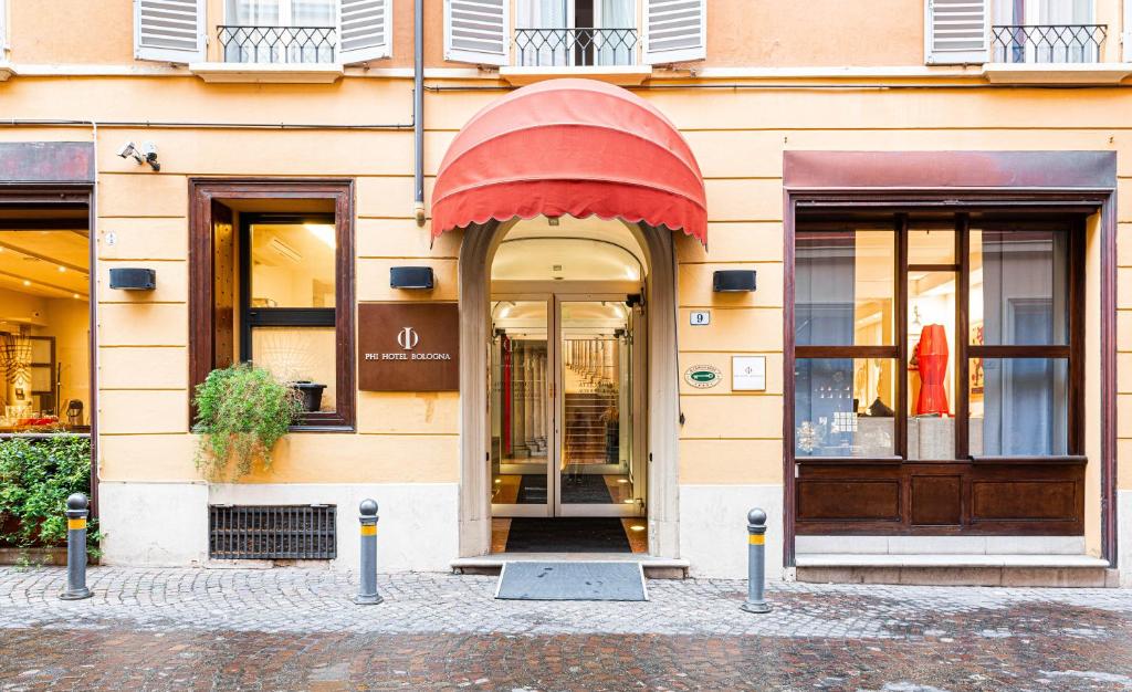a store front of a building with a red awning at Phi Hotel Bologna in Bologna