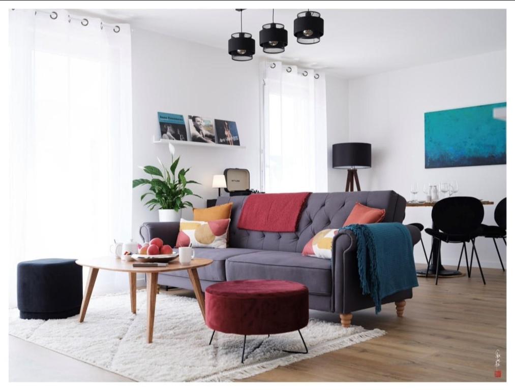 un salon avec un canapé bleu et une table dans l'établissement Appart entre Paris et Disney - inclus Park et Wifi, à Champs-sur-Marne