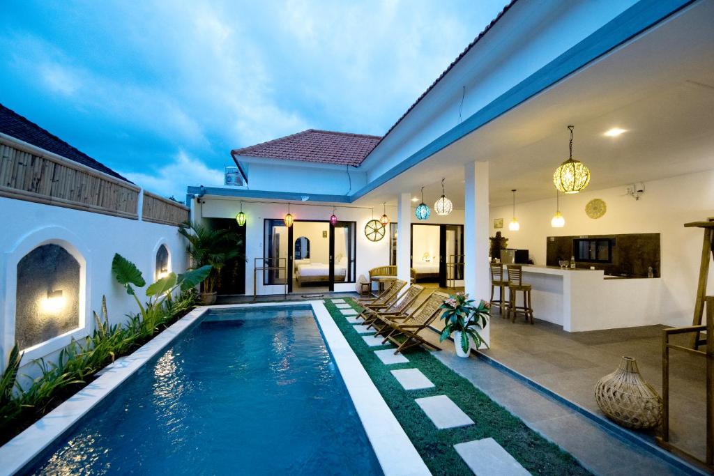 a villa with a swimming pool and a house at YO Villa Canggu in Canggu