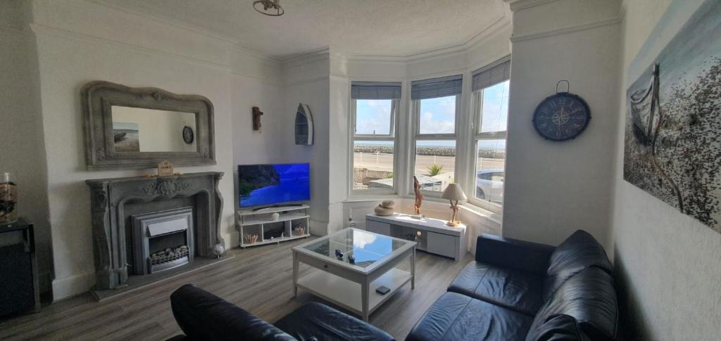 a living room with a couch and a fireplace at Stunning Beachfront Apartment Sleeps 4 in Rhos-on-Sea