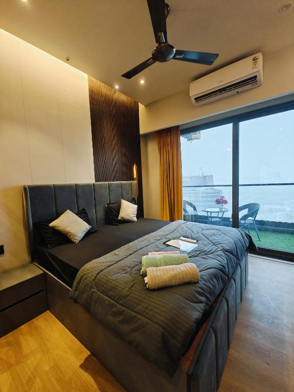 a bedroom with a large bed with a ceiling fan at Luxurious suite with City view in Ghaziabad