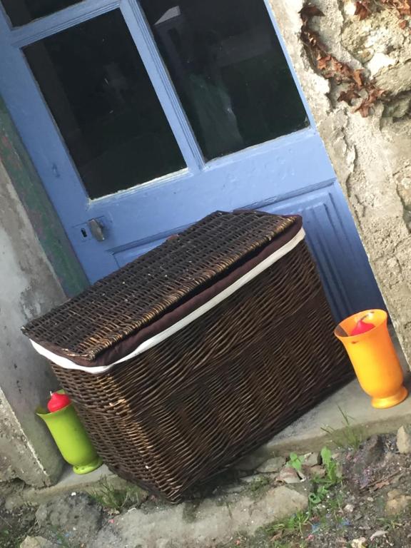 a wicker basket sitting in front of a door at Linotte Chaumière des Marionnettes in La Chapelle-des-Marais