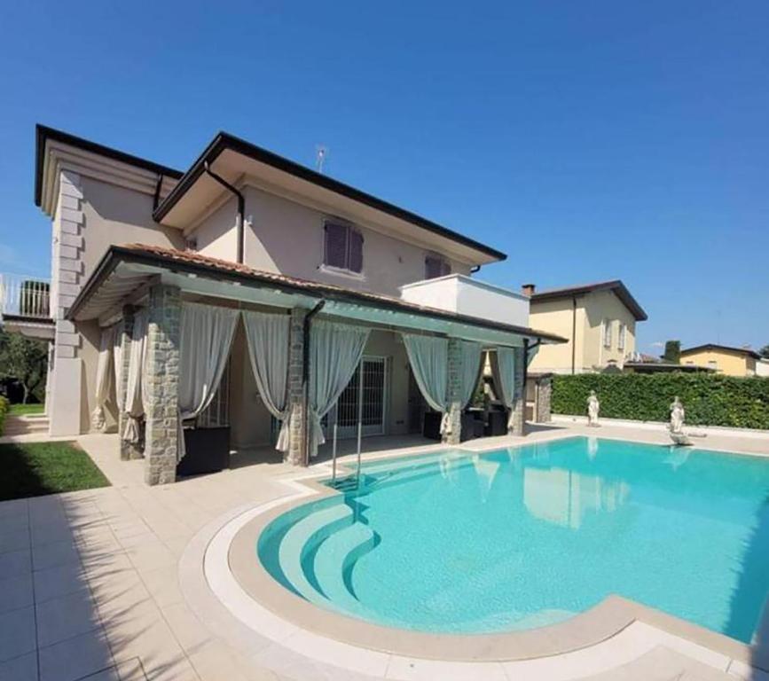 a large swimming pool in front of a house at Villa Giuly in Sirmione
