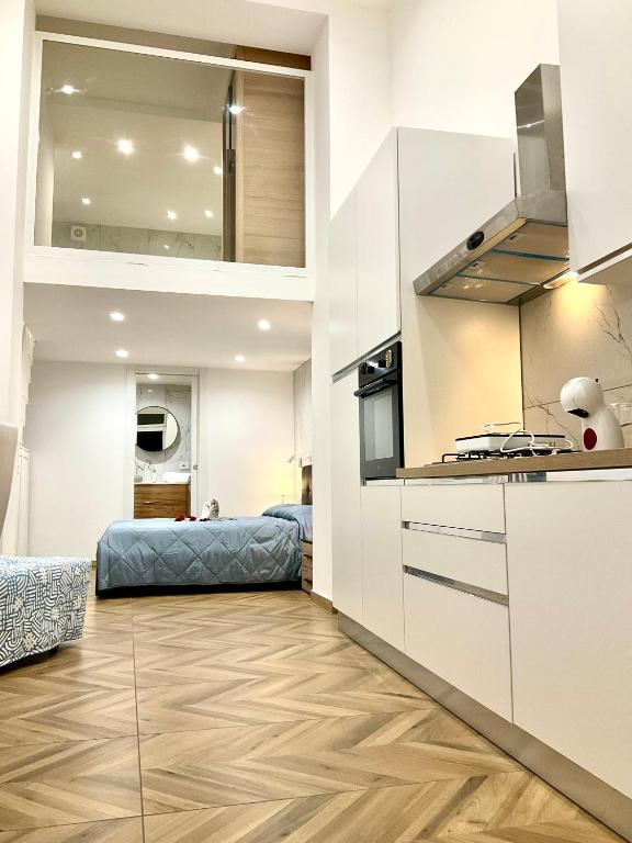 a kitchen with white cabinets and a bed in a room at Gold suite19 in Catania
