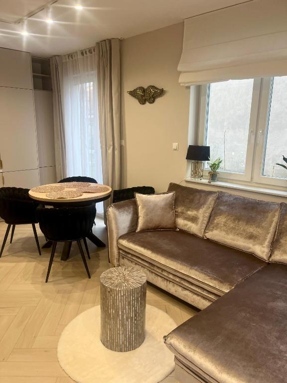 a living room with a couch and a table at Apartament Kaszmirowy in Bielsko-Biała