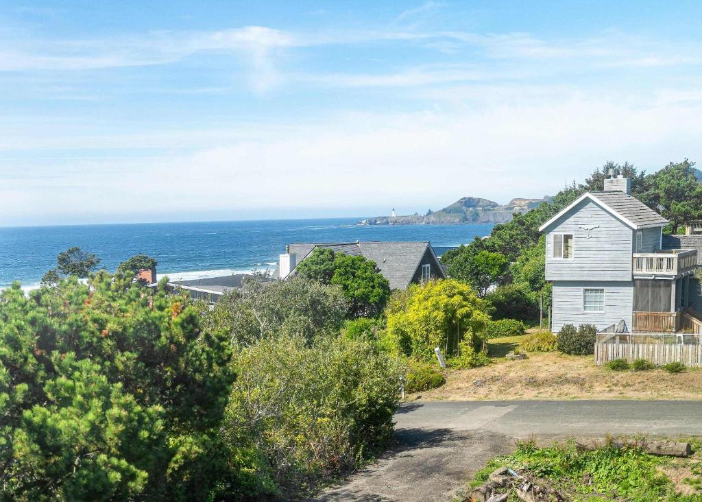 una casa su una collina con l'oceano sullo sfondo di Coastal Retreat with Ocean Views and Hot Tub a Newport