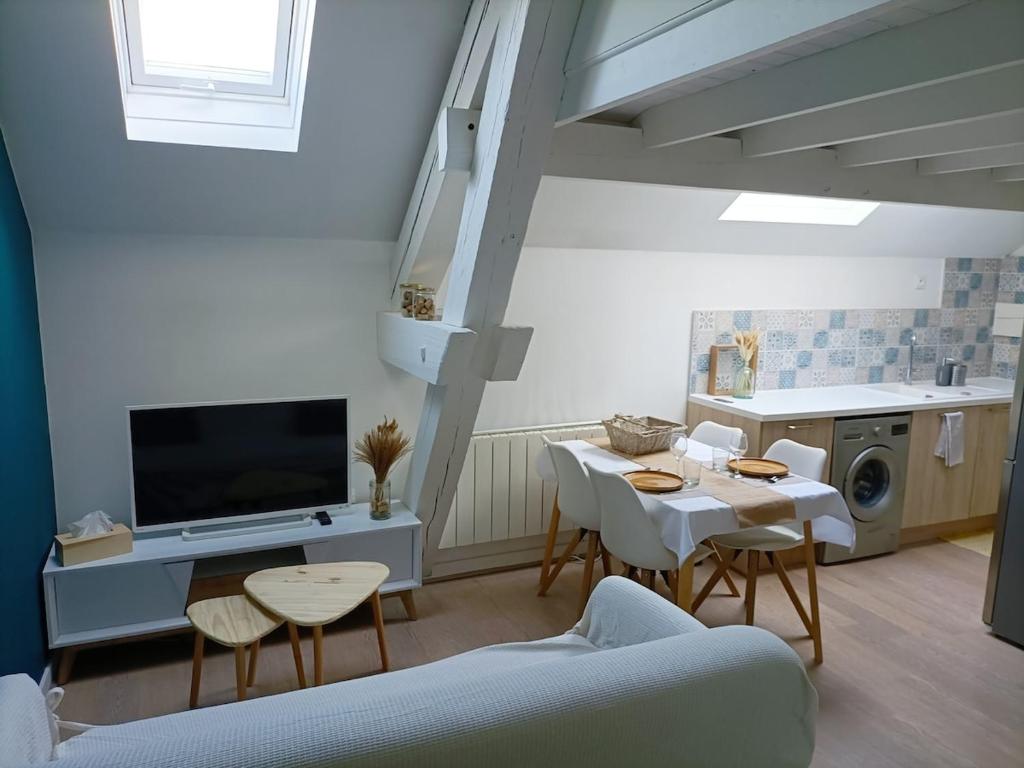 un salon avec une télévision, une table et des chaises dans l'établissement Le pied-à-terre des bains, à Aix-les-Bains