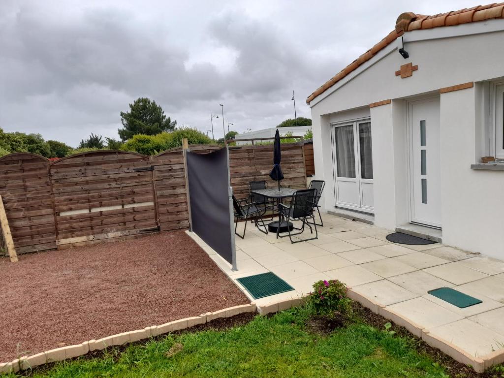 een patio met een tafel en een hek bij La petite maison studiot in Pornic