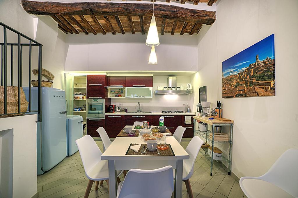 a kitchen and dining room with a table and chairs at Cozy Apartment in the heart of Siena in Siena