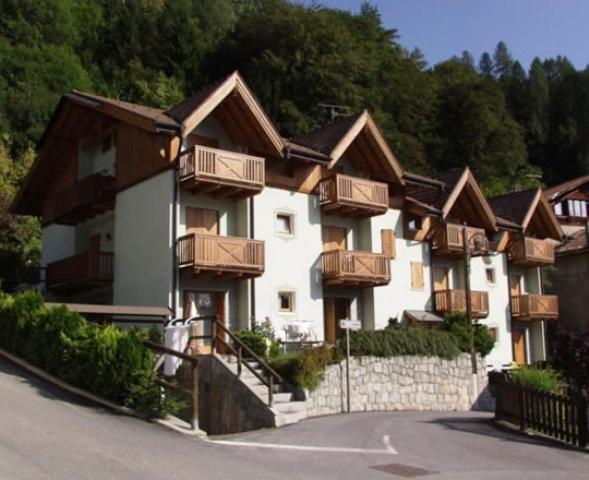 a building with wooden balconies on the side of a road at Residenza Al Castello in Massimeno