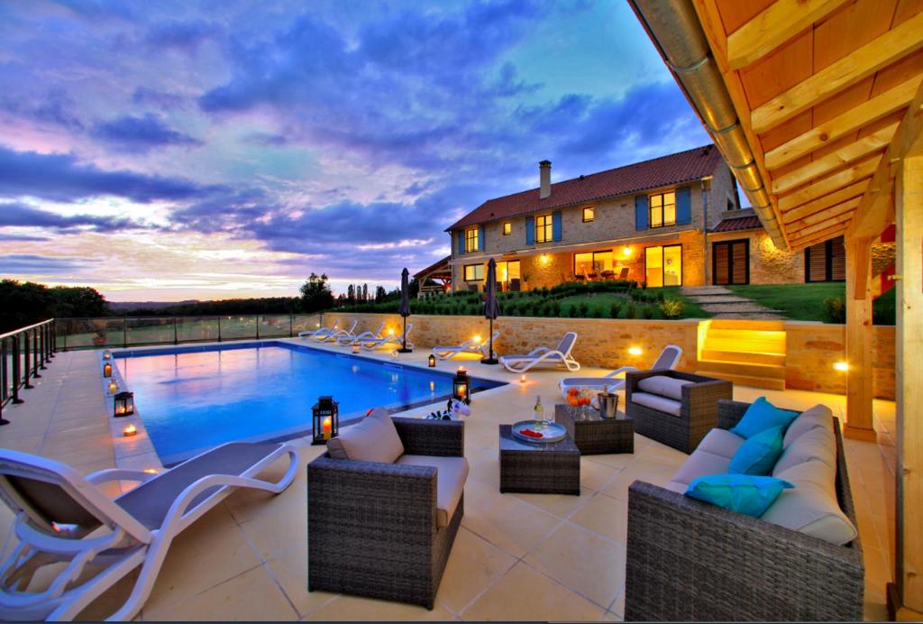 un patio avec une piscine et une maison dans l'établissement La Marquaysserie du Domaine de la Malonie, à Sarlat-la-Canéda