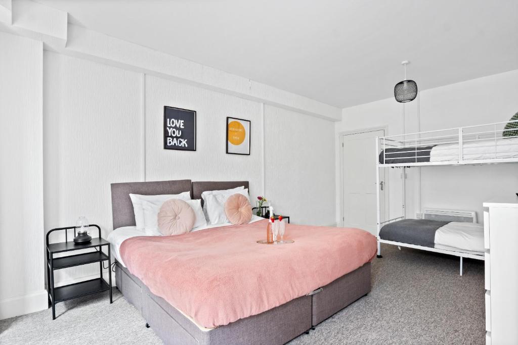 a bedroom with a bed with a pink blanket at Spacious one bed Apartment, contractor friendly, Sleeps 6, FREE Secure Parking, Near Beach in Bournemouth