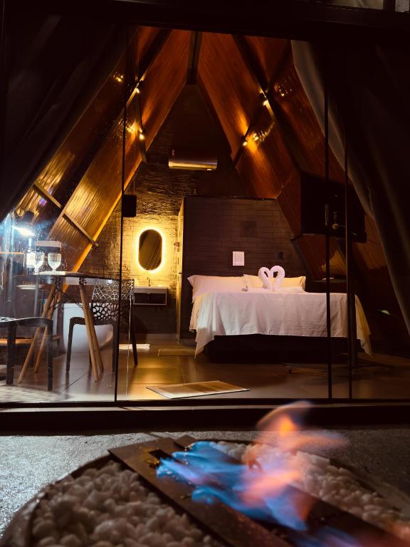 ポソス・デ・カルダスにあるMontreal Cabanasの鏡付きの部屋にベッド1台が備わるベッドルーム1室があります。