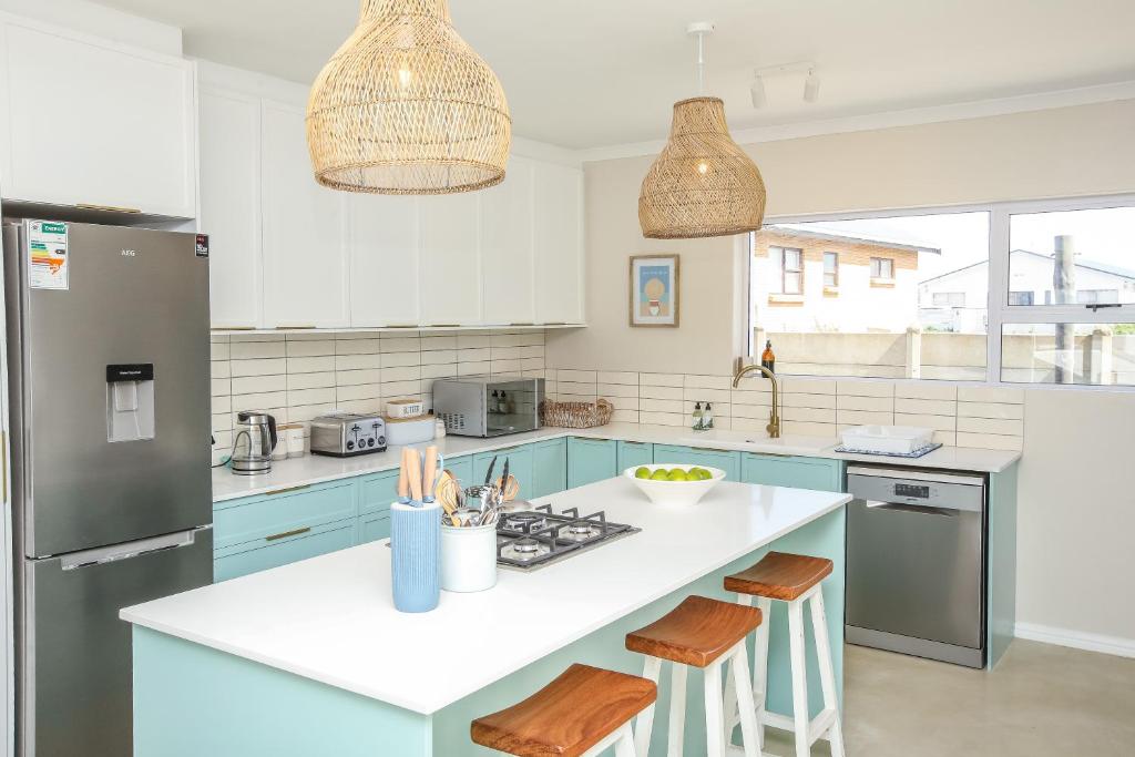 a kitchen with blue cabinets and a white counter top at Casa Azul Downstairs Apartment in Struisbaai