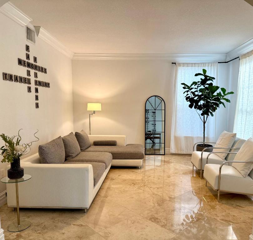 ein Wohnzimmer mit einer Couch und zwei Sesseln in der Unterkunft Miami Getaway Heated Pool Villa with Mini Golf &amp; BBQ in Miami