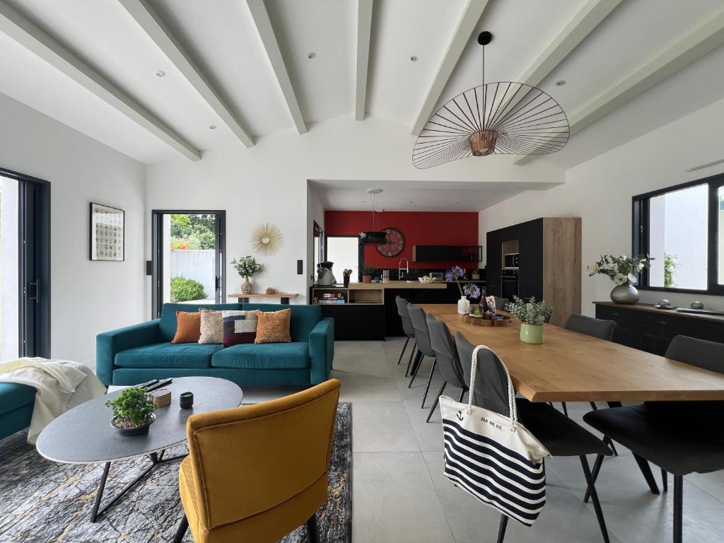 un salon avec un canapé bleu et une table dans l'établissement New Rethaise holiday home 8 people, au Bois-Plage-en-Ré