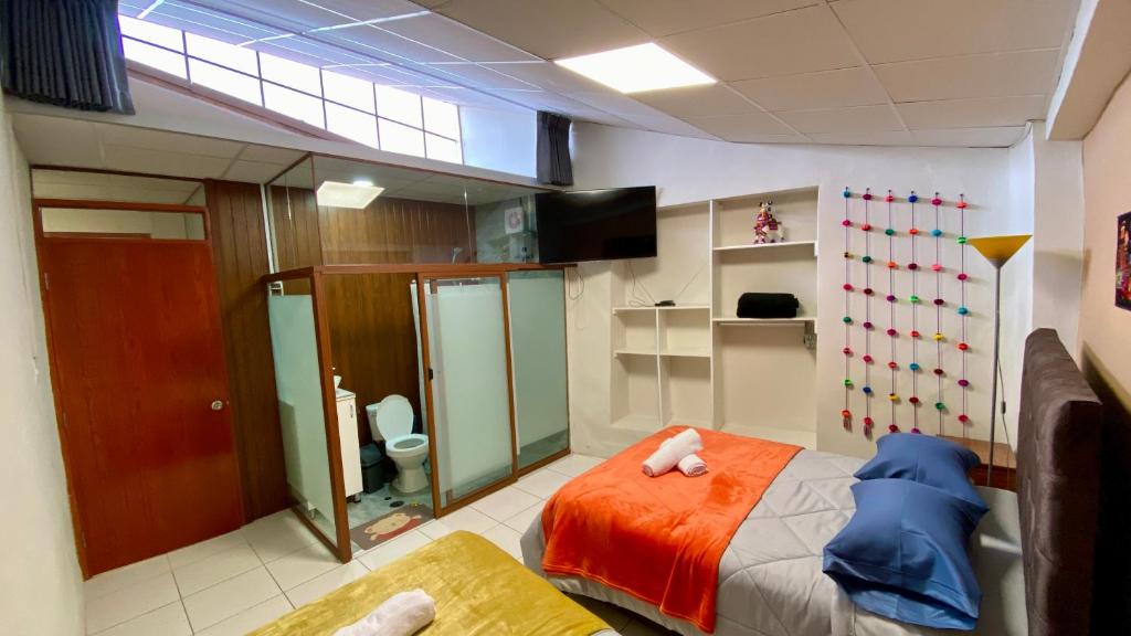 a bedroom with a bed with orange sheets at Templo de la Luna Pardo in Cusco