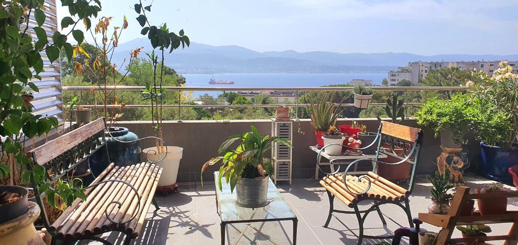 d'un balcon avec des chaises et des tables offrant une vue sur l'eau. dans l'établissement T3 vue mer proche plage, à Ajaccio