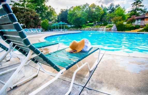 a hat sitting on a bench next to a swimming pool at Partee Bungalow At Margaritaville in Osage Beach