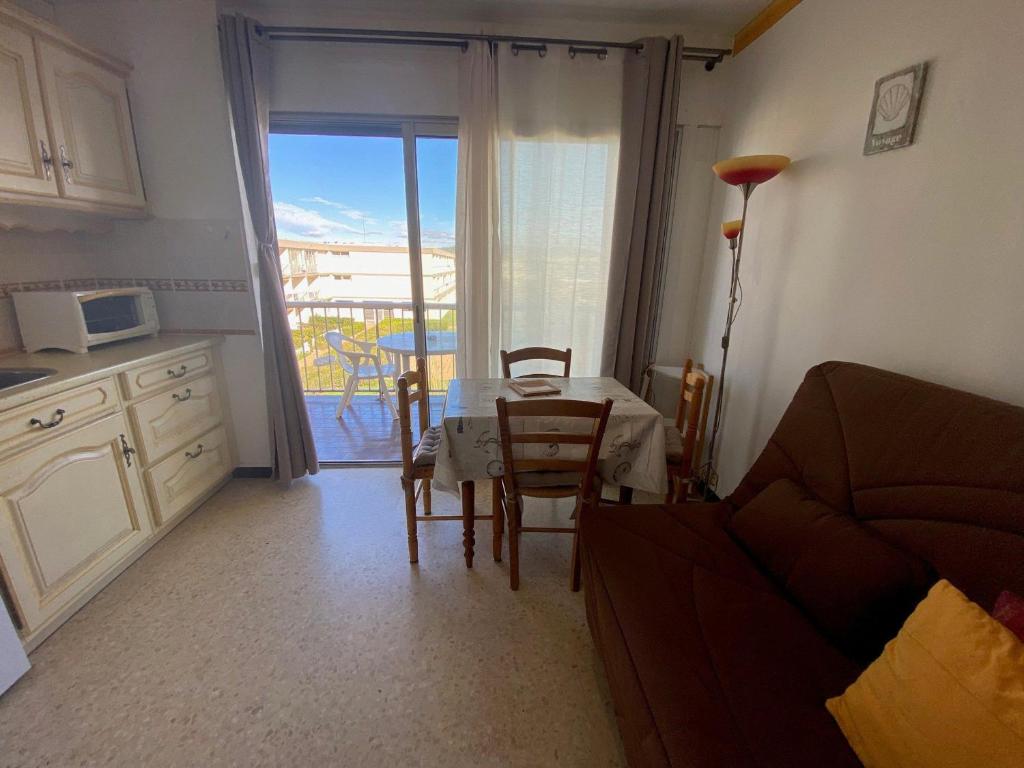 un salon avec une table et une cuisine dans l'établissement Appartement cosy avec balcon et climatisation à Balaruc-les-Bains - FR-1-503-179, à Balaruc-les-Bains