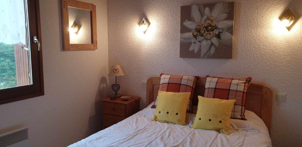 une chambre avec un lit avec des draps blancs et des oreillers dans l'établissement Le petit Pinson, à Font-Romeu-Odeillo-Via