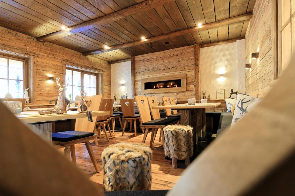 a dining room with tables and chairs and a fireplace at Hotel Schwarzenberg in Glottertal