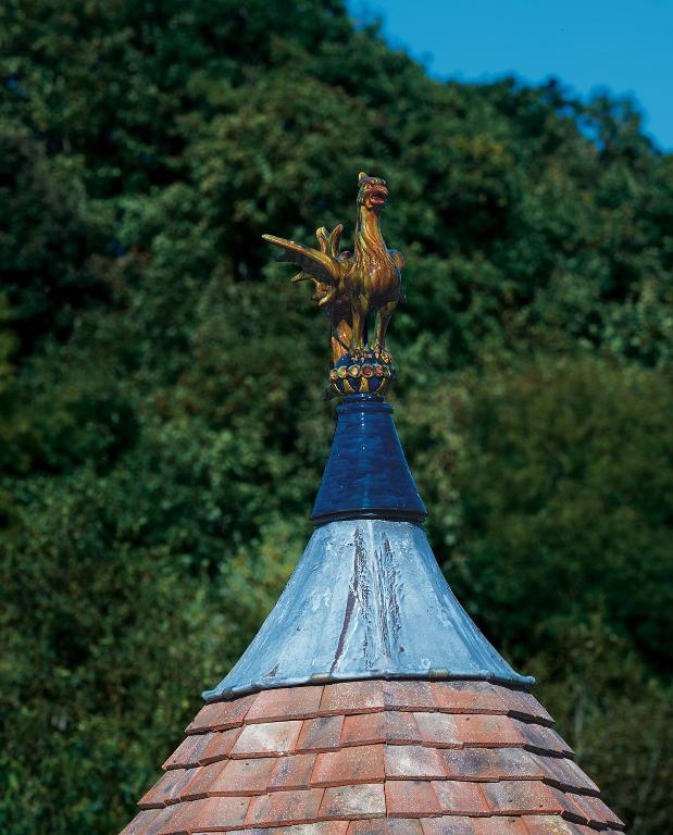 une statue d'un coq au-dessus d'un bâtiment dans l'établissement La porte bleue, à Trouville-sur-Mer