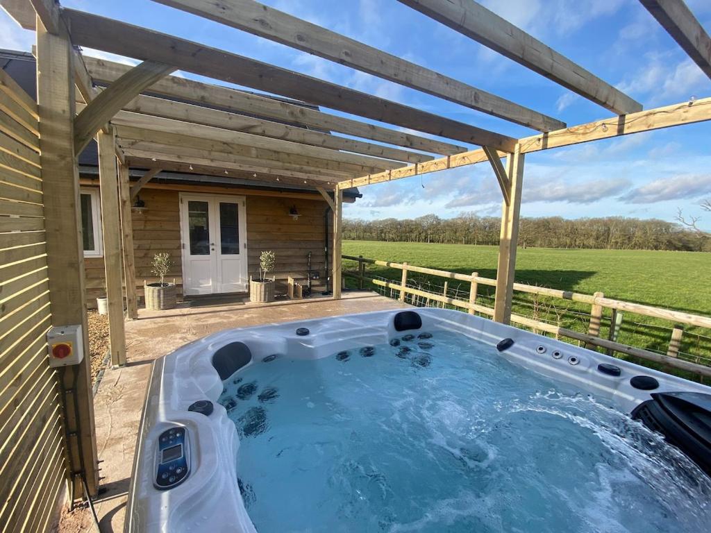 a hot tub on a patio with a pergola at Luxury Boutique retreat, hot tub, dog friendly in Hanmer