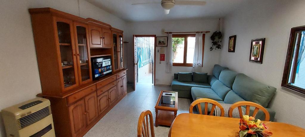 sala de estar con sofá azul y mesa en Bungalow Catral 20 en Santa Pola, en Santa Pola