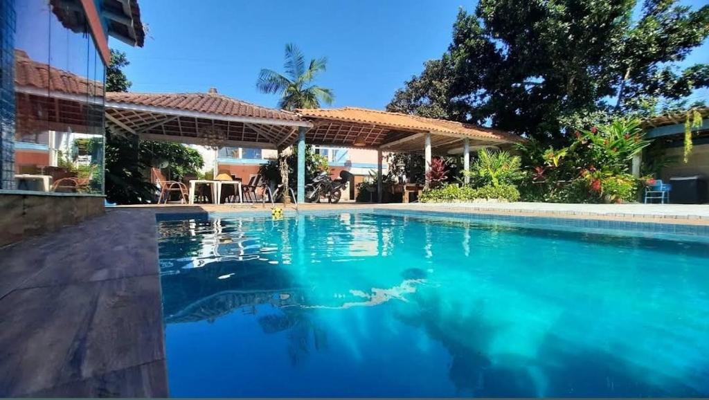 a swimming pool in front of a house at Suites Baleia Verde in São Sebastião