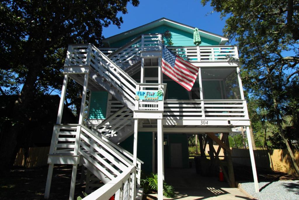 a house with an american flag on the porch at Flip Flop Casual in Folly Beach