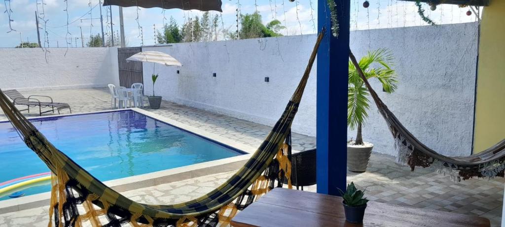 a hammock in front of a swimming pool at FLAT BRISA do MAR in Pitimbu