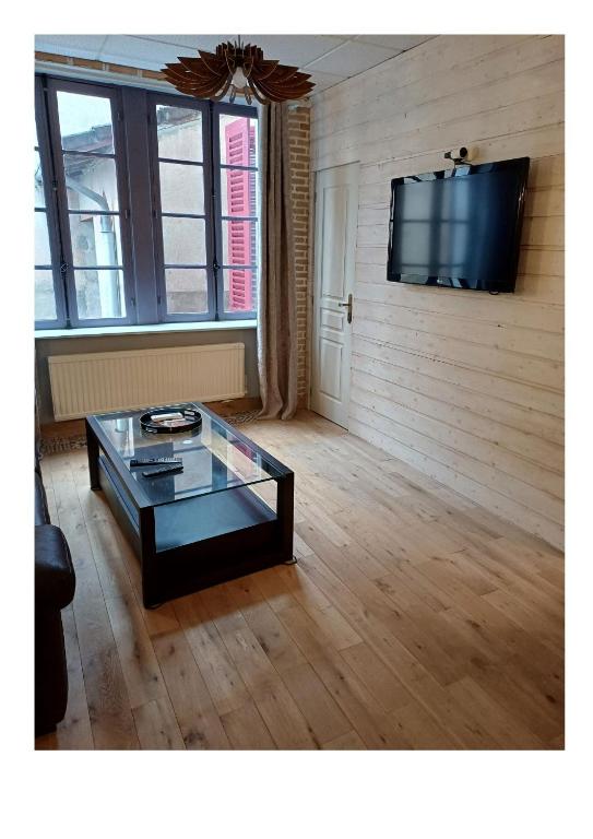 un salon avec une table basse et une télévision à écran plat dans l'établissement L'appart de la Rivière, à Moulins