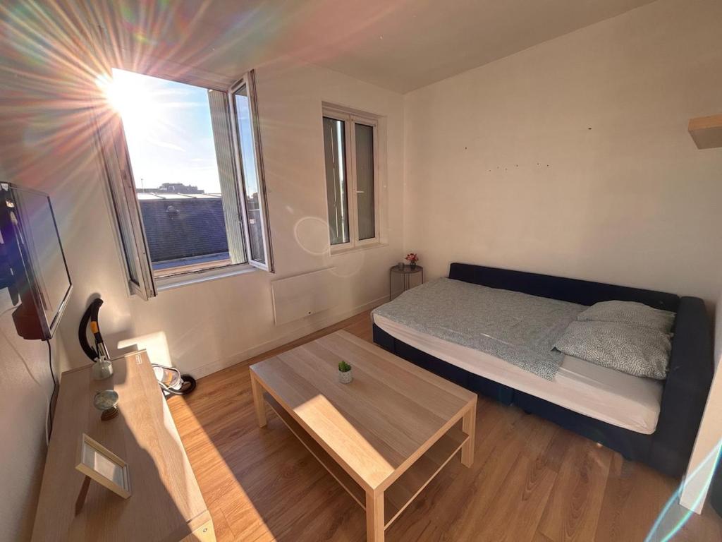 une petite pièce avec un lit et une table dans l'établissement Les Ours - Studio Centre Ville, à Rouen