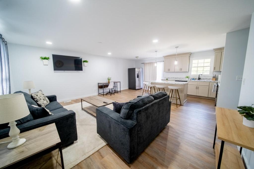 a living room with two couches and a kitchen at Southern Serenity Cottage in Wendell