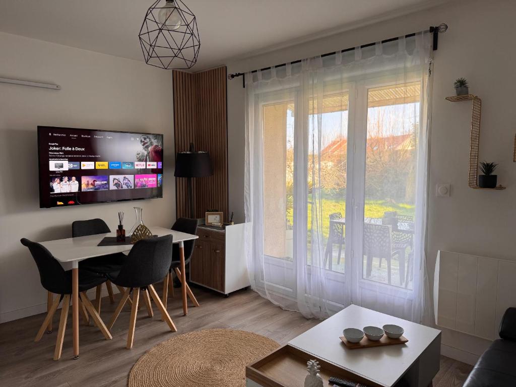 un salon avec une table et une salle à manger dans l'établissement Cottage l'Echappée Belle, à Saint-Amand-les-Eaux
