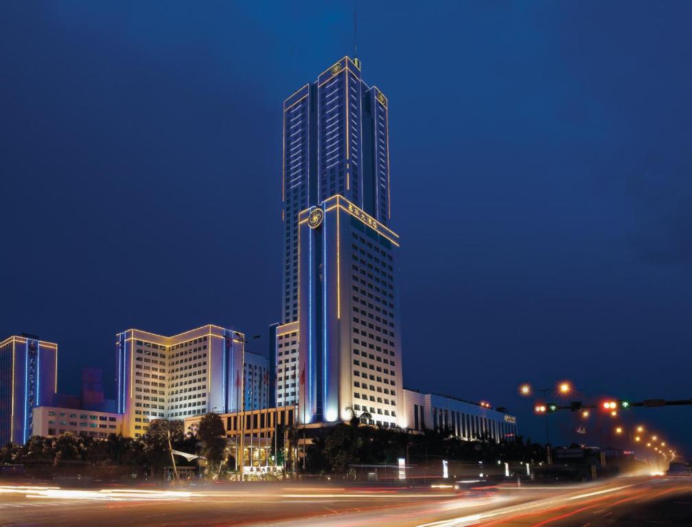 un edificio alto con luces encendidas por la noche en Regal Palace Hotel, en Dongguan