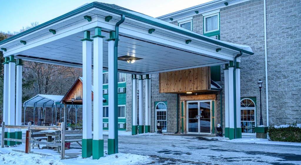 Un pabellón fuera de un edificio con nieve en el suelo. en Westgate Inn, en Coudersport