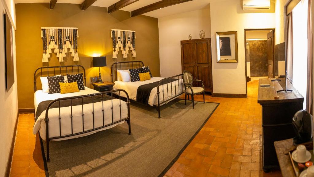 a bedroom with two beds and a living room at Hacienda El Salitre Hotel & Spa in Querétaro
