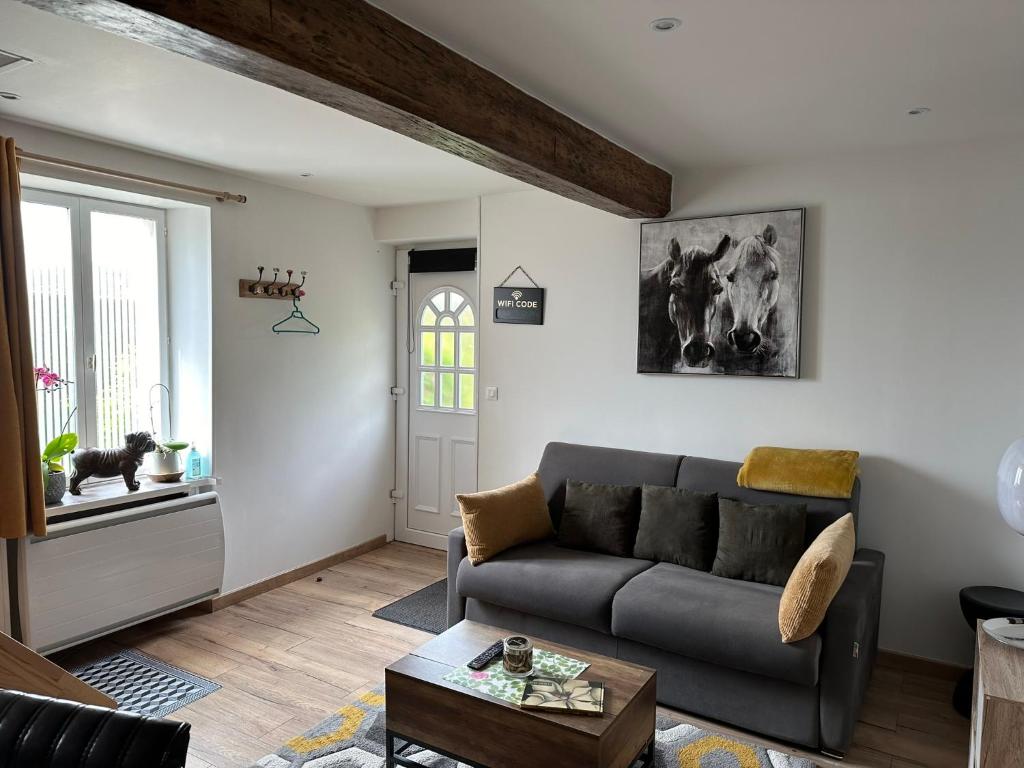 un salon avec un canapé et une table dans l'établissement cottage Philippe et Valérie, à Silli-en-Gouffern