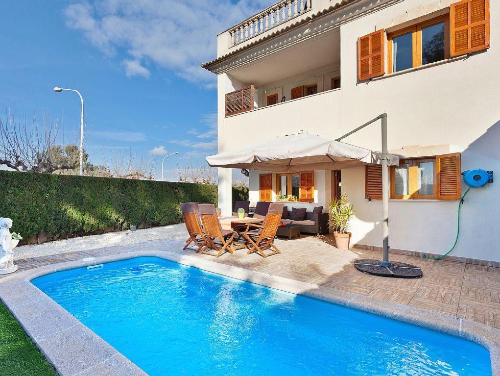 a villa with a swimming pool in front of a house at Casa Paraiso de Alcudia in Port d'Alcudia