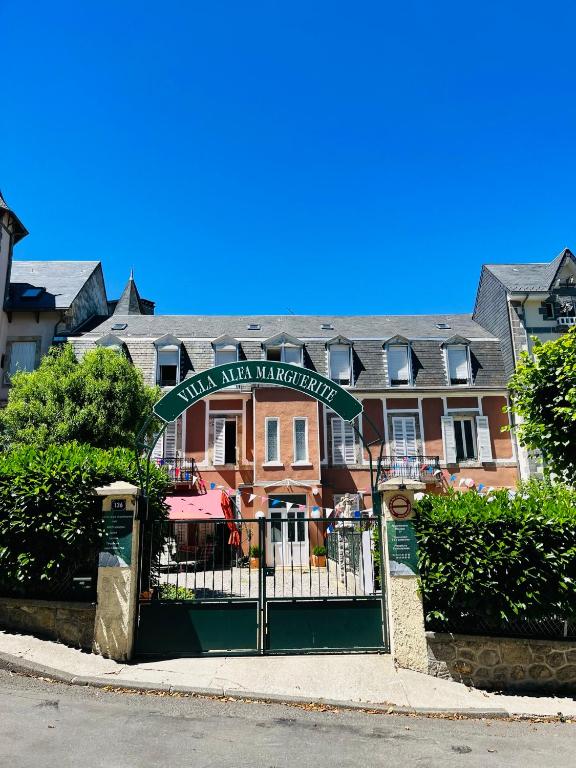 un bâtiment avec une porte et un panneau devant lui dans l'établissement F1 Tulipe, à La Bourboule