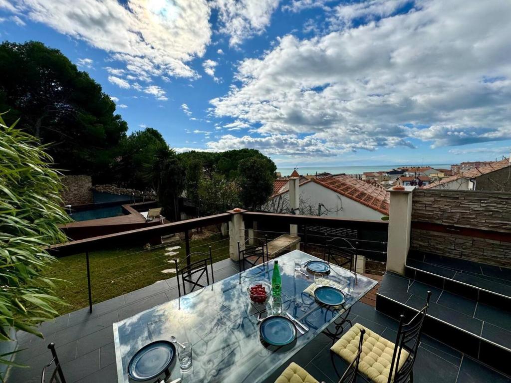 d'une terrasse avec une table en verre et des chaises sur un balcon. dans l'établissement Le bateau de Sète, à Sète