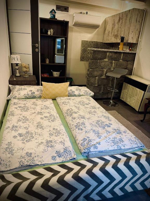 a bed with two pillows on it in a room at Guszti 2 Apartman in Pécs